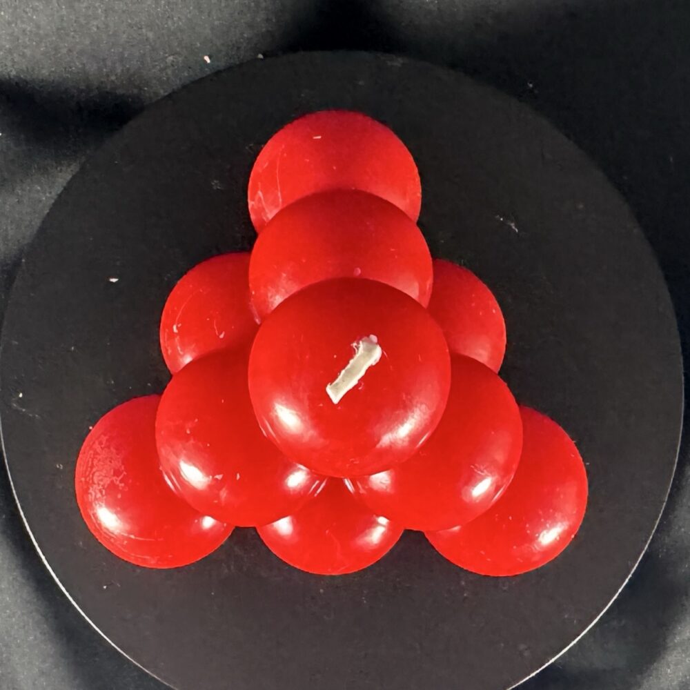 Bougie artisanale rouge en forme de pyramide de bulles, coulée à la main en cire minérale et végétale. Création boo-j, au design ludique et festif.