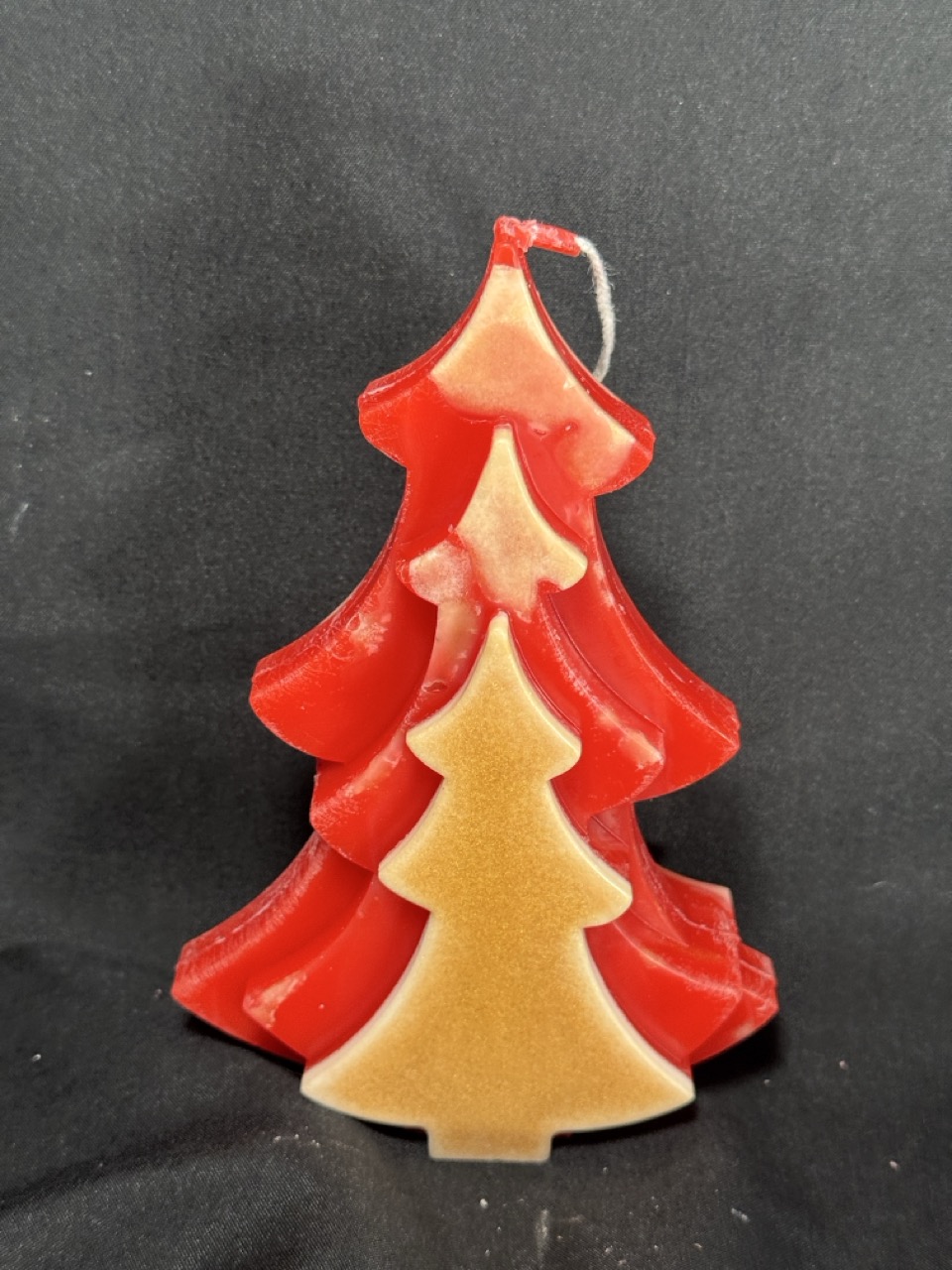 Bougie artisanale en forme de sapin rouge et doré, coulée à la main en cire minérale et végétale, création boo-j réalisée dans le canton de Vaud.