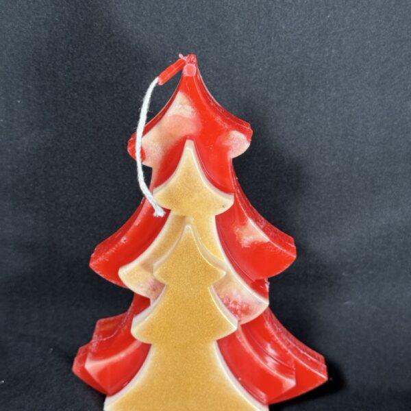 Bougie artisanale en forme de sapin rouge et doré, coulée à la main en cire minérale et végétale, création boo-j réalisée dans le canton de Vaud.