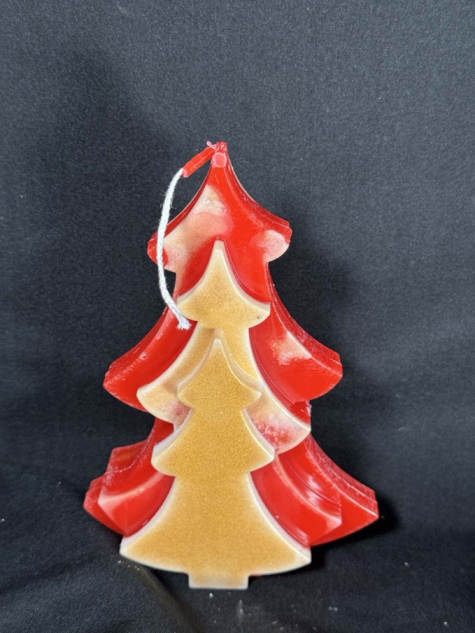 Bougie artisanale en forme de sapin rouge et doré, coulée à la main en cire minérale et végétale, création boo-j réalisée dans le canton de Vaud.