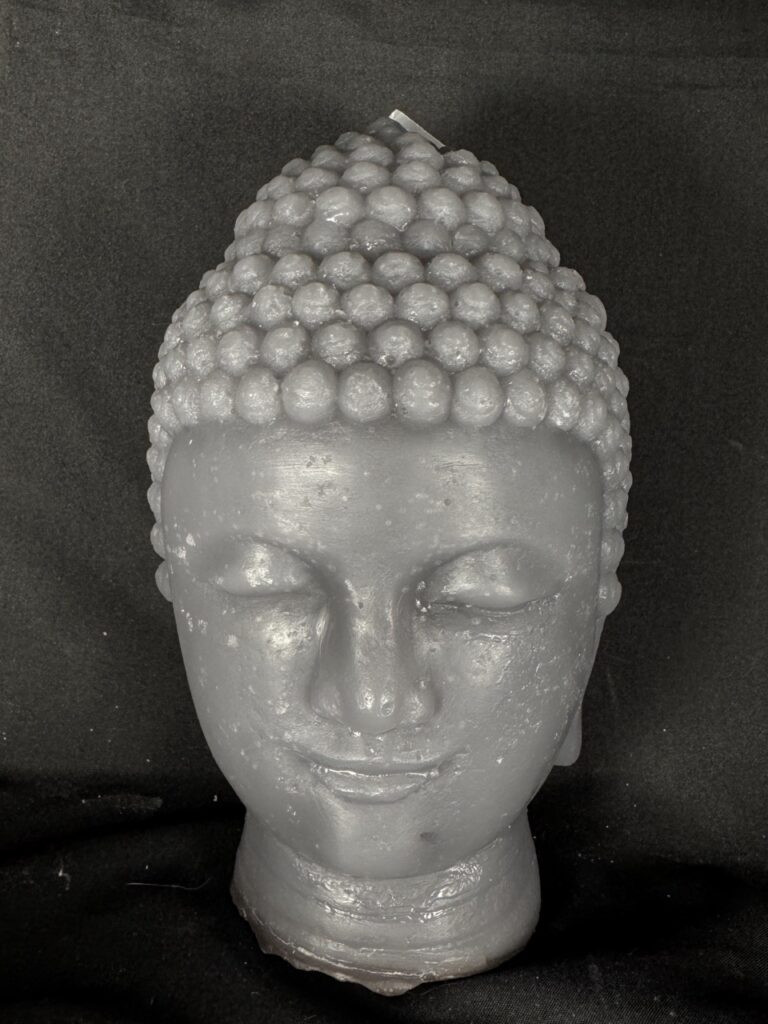 Bougie moulée visage bouddha gris, posée sur des galets, création artisanale en cire boo-j