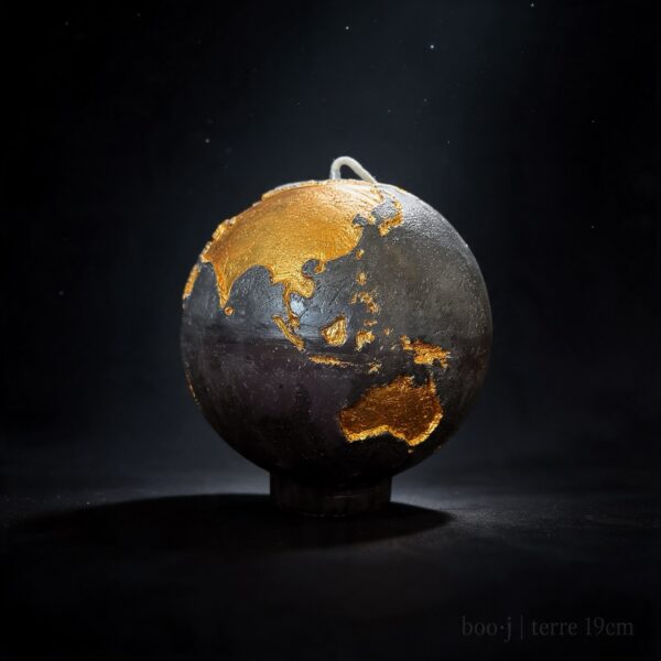 Grande bougie sphérique exclusive boo·j de 19 cm, fait main, représentant la Terre noire avec continents en couleur or foncé, pièce maîtresse de la collection.