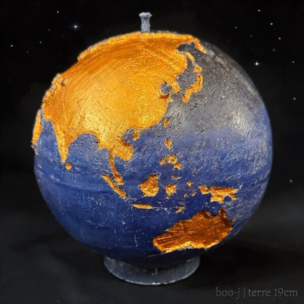 Grande bougie sphérique exclusive boo·j de 19 cm, fait main, représentant la Terre avec continents en couleur or foncé sur fond bleu nuit, pièce maîtresse de la collection.