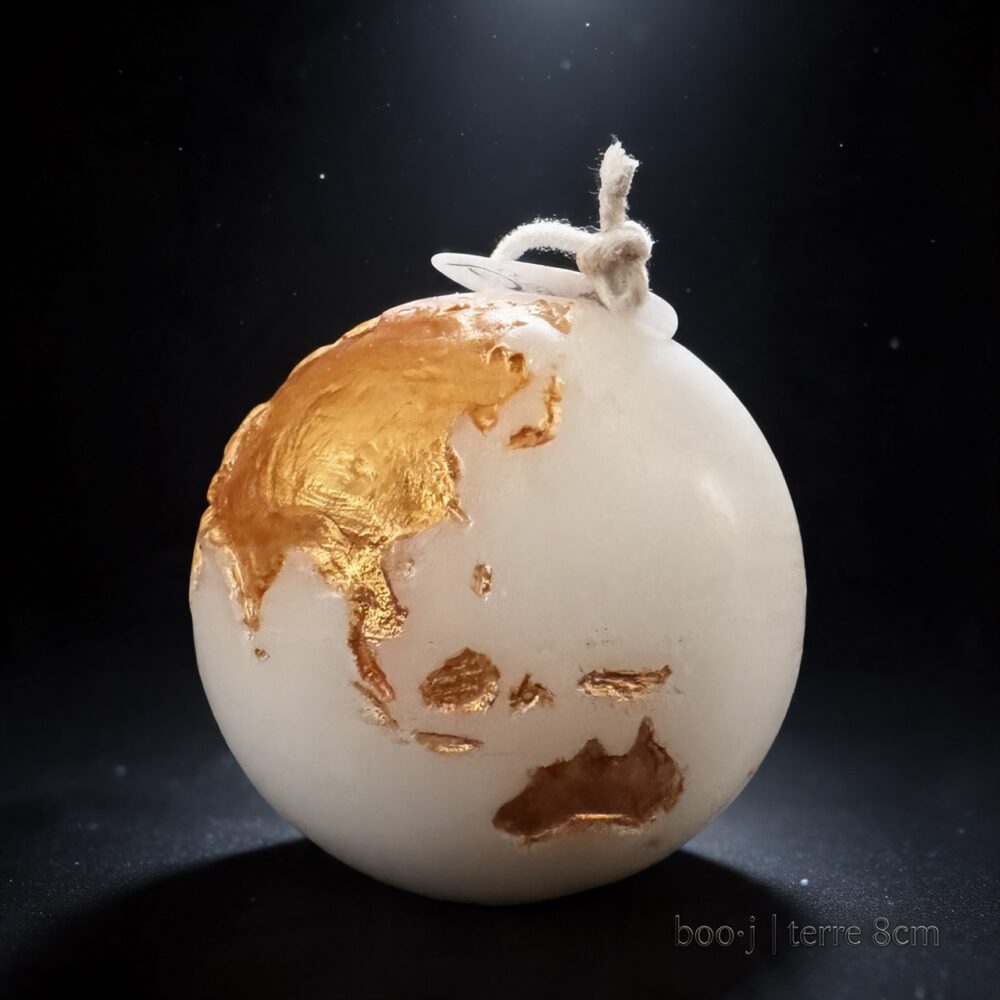 Bougie Sphère Terre 8 cm – Exclusive boo·j Fait Main Bougie sphérique exclusive boo·j de 8 cm, fait main, représentant la Terre avec continents en or foncé sur fond blanc.